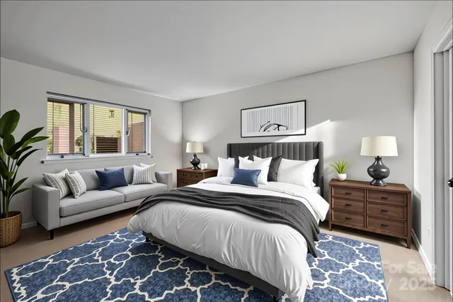 a spacious bedroom with a bed a couch and windows