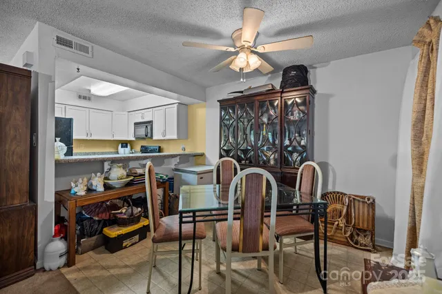 a view of a dining room with furniture a chandelier and window