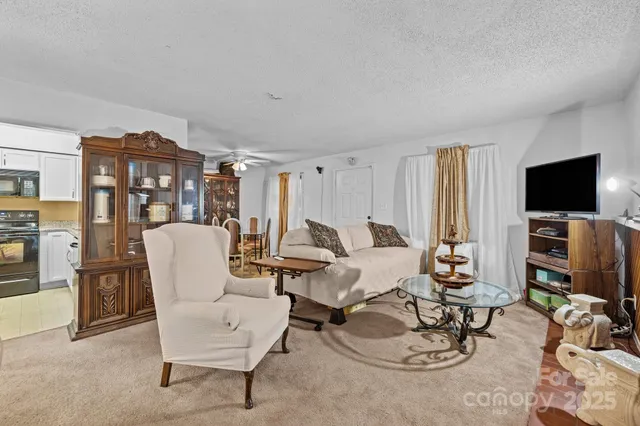a living room with furniture a flat screen tv and floor to ceiling window