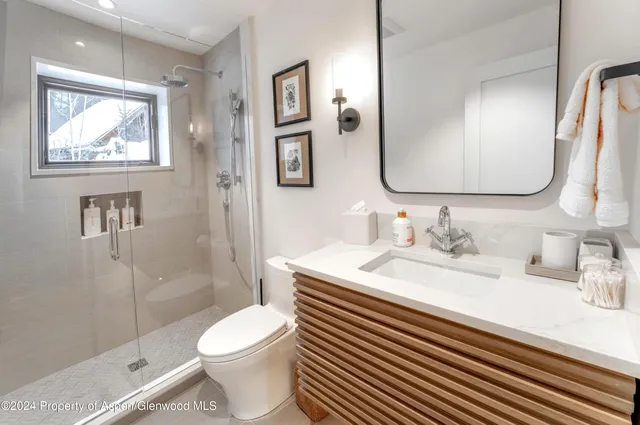 a bathroom with a granite countertop toilet sink and a mirror