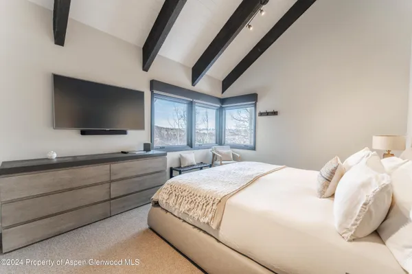 a bedroom with a large bed and a flat screen tv