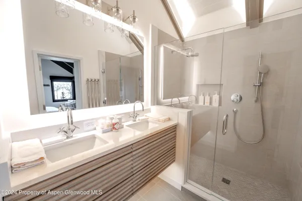 a bathroom with a granite countertop sink a mirror and a shower