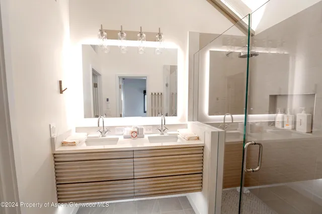 a bathroom with a sink a mirror and shower