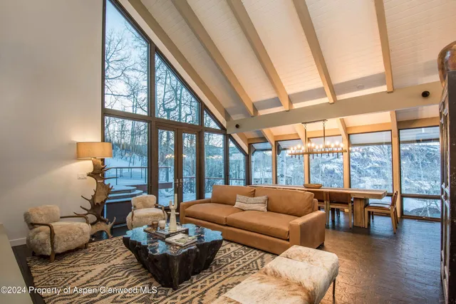 a living room with furniture and a floor to ceiling window