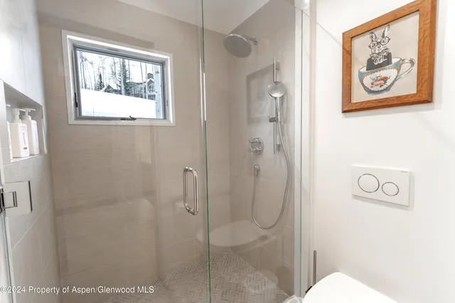 a bathroom with a painting on the wall and shower