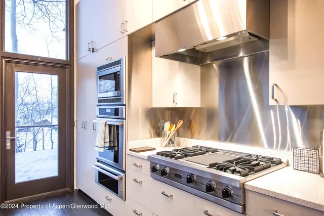 a kitchen with stainless steel appliances granite countertop a stove and a refrigerator