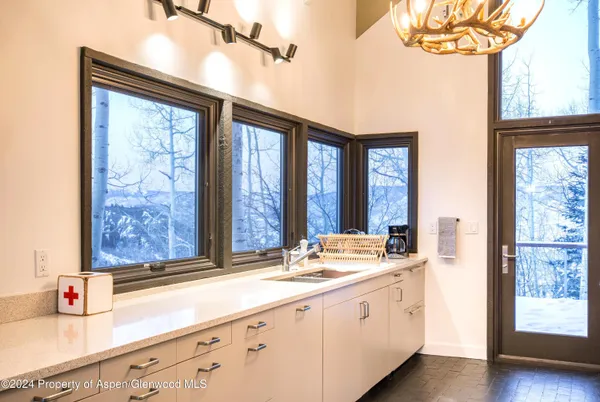 a bathroom with a granite countertop sink and a large mirror next to a window