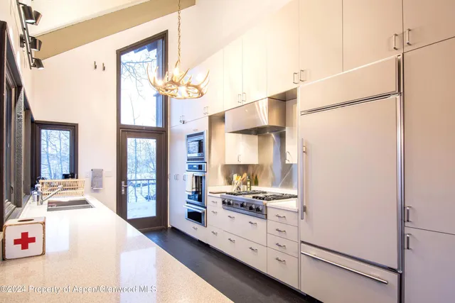 a open kitchen with stainless steel appliances a refrigerator and a stove