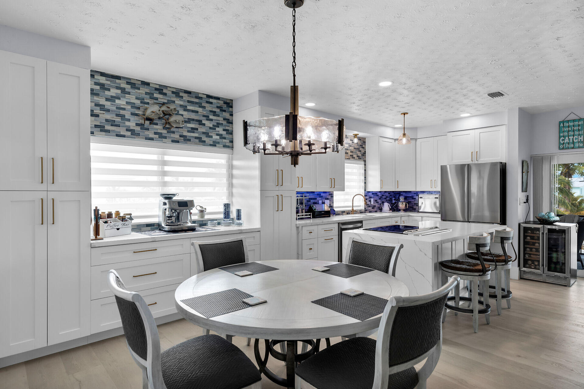 30363 Flamingo Lane Big Pine Key, FL 33043 - Photo 18 of 43 a kitchen with kitchen island a dining table chairs and a chandelier