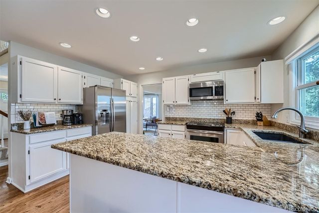 a kitchen with stainless steel appliances granite countertop a sink stove and refrigerator