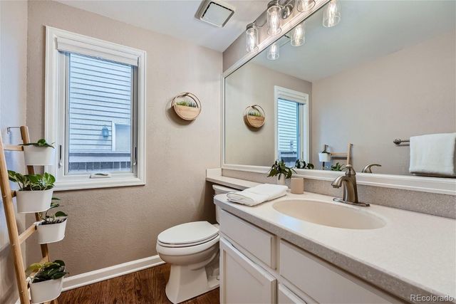 a bathroom with a granite countertop sink a toilet and mirror