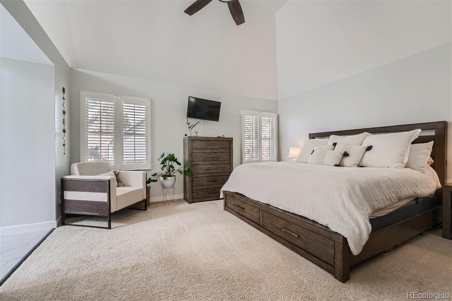 16671 East Prentice Circle Centennial, CO 80015 - Photo 26 of 40 a spacious bedroom with a bed a couch and a flat screen tv