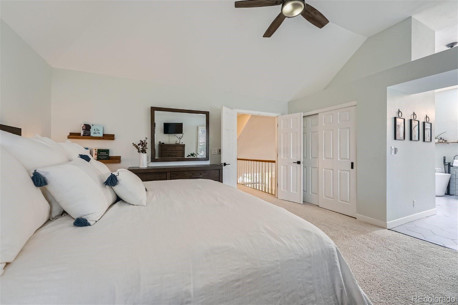 16671 East Prentice Circle Centennial, CO 80015 - Photo 27 of 40 a bedroom with a large bed and a chandelier