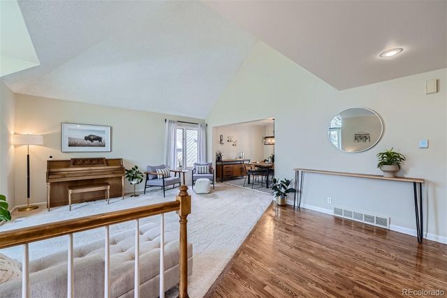 a living room with furniture a piano and wooden floor