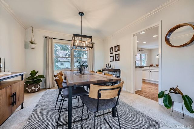 a view of a dining room and livingroom with furniture wooden floor a chandelier