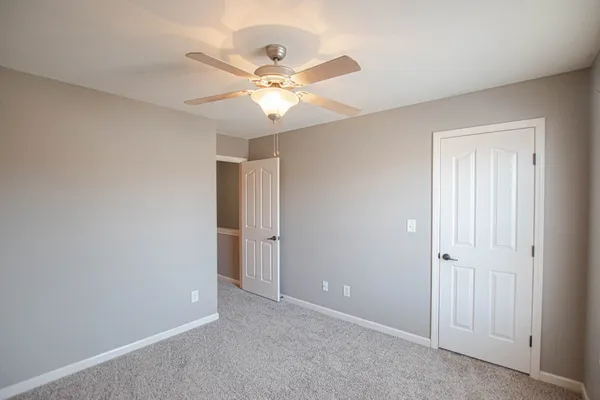 an empty room with a ceiling fan and a window