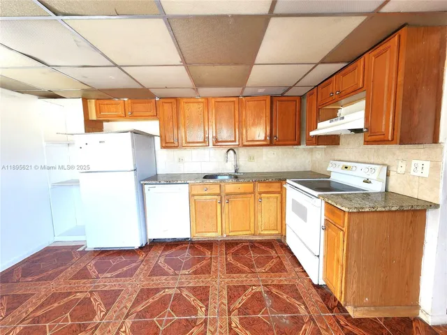 a kitchen with granite countertop a sink and a stove top oven