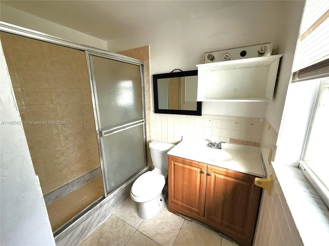 an empty room with a window and a ceiling fan