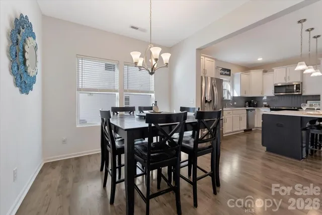 a view of a dining room with furniture a chandelier and wooden floor