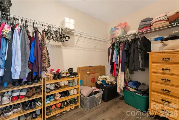 a view of walk in closet with clothes and shoes