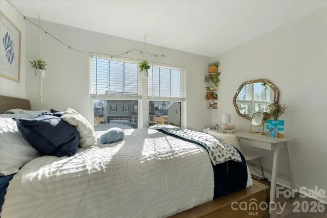 a bed sitting in a bedroom next to a window with dresser