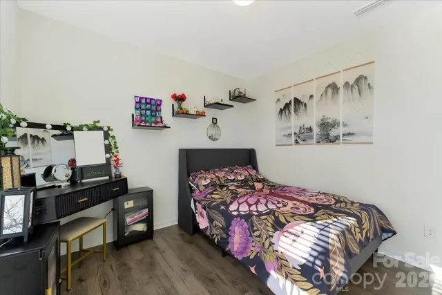 a bedroom with a bed and a flat tv screen on the dresser
