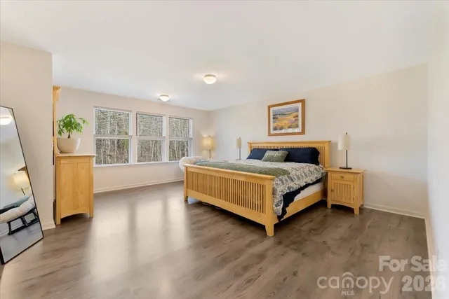 a spacious bedroom with a bed a couch and a window