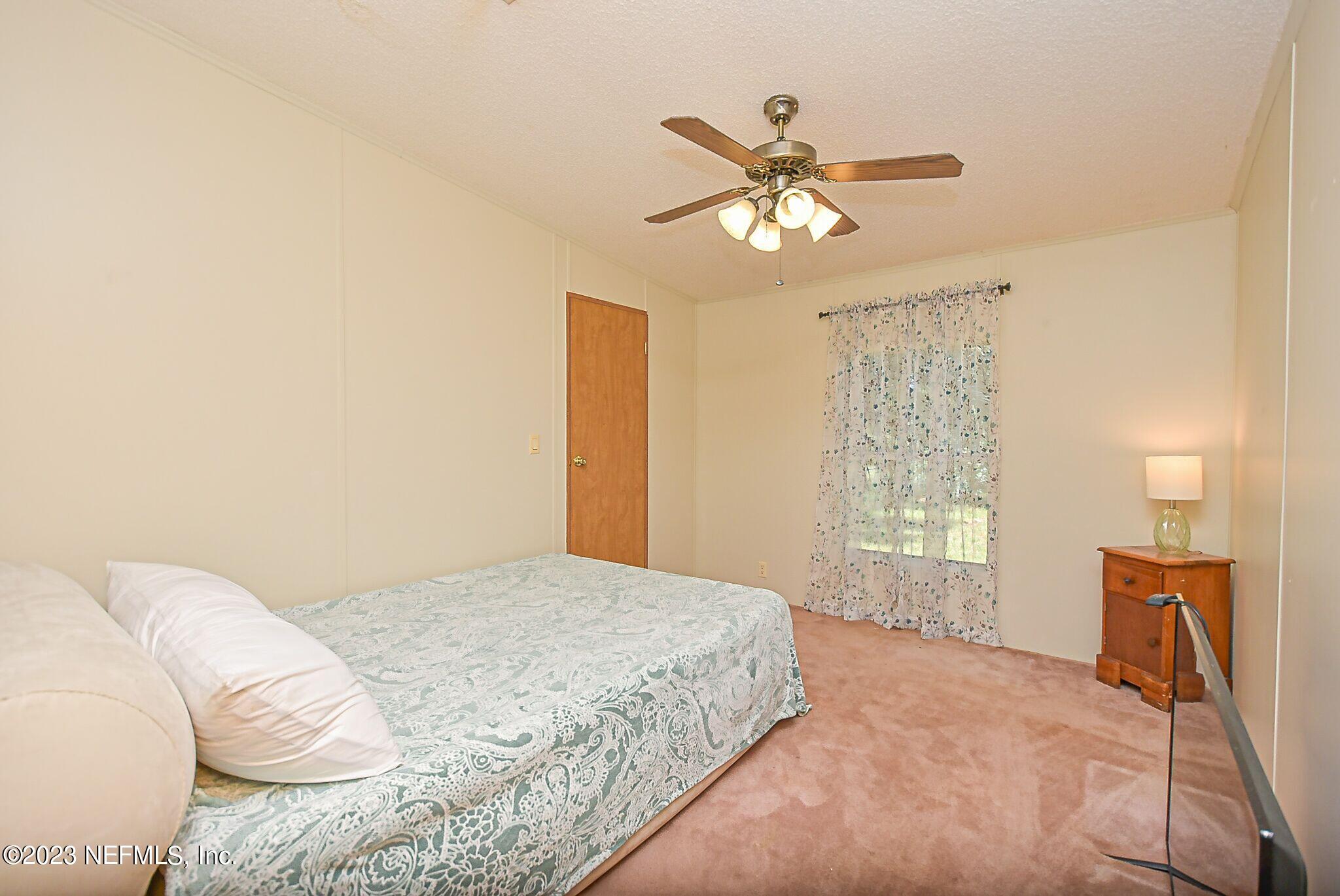 136 Lawrence Lane Georgetown, FL 32139 - Photo 20 of 33 a bedroom with a bed and a chandelier