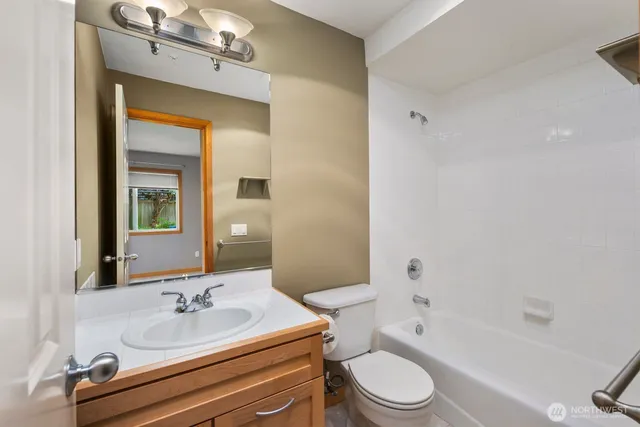 a bathroom with a granite countertop sink toilet a mirror and bathtub