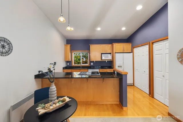 a kitchen with stainless steel appliances granite countertop a sink and a wooden floor