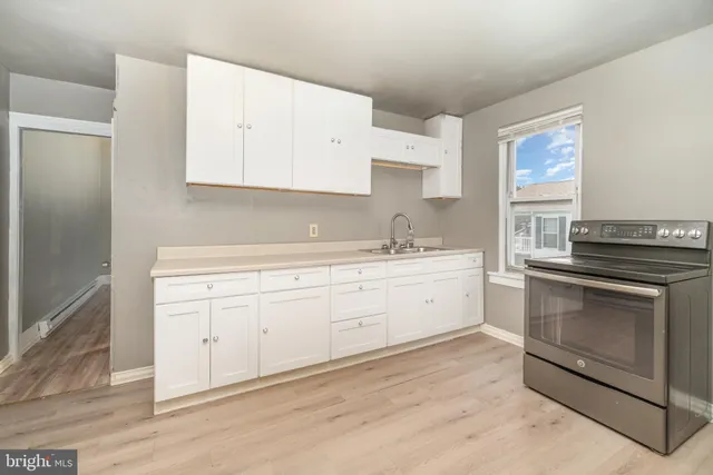a kitchen with white cabinets stainless steel appliances and sink
