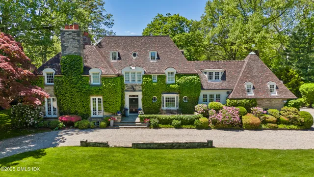 front view of house with a yard and potted plants