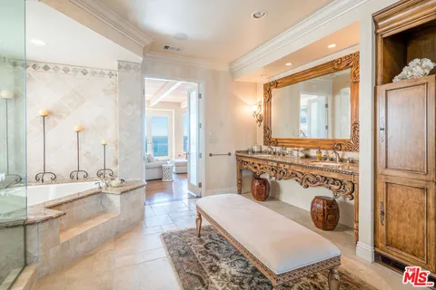 a en suite bathroom with a tub a sink and mirror