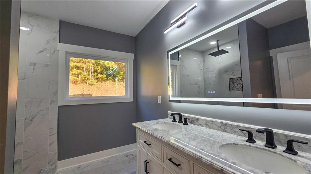 49 Sweetgum Street Talmo, GA 30575 - Photo 19 of 36 a bathroom with a granite countertop sink a mirror and a window
