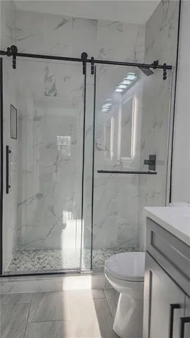 a bathroom with a shower a toilet and sink