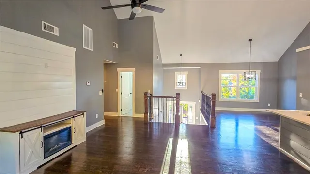 a view of empty room with wooden floor and fan