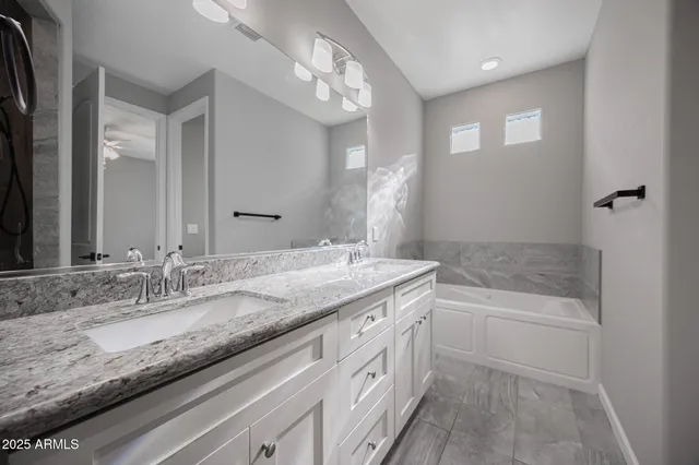 a bathroom with a granite countertop sink a mirror and a shower