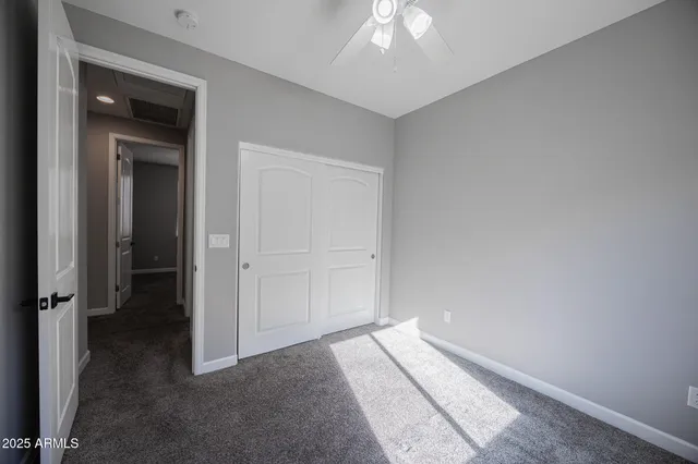 an empty room with a chandelier fan