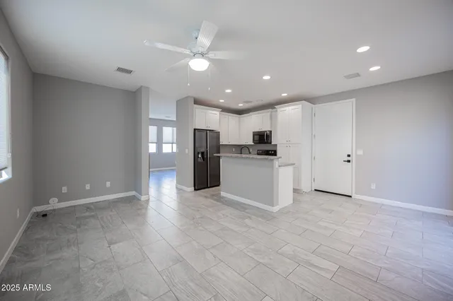 a view of kitchen with refrigerator and a stove top oven