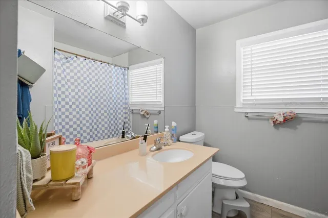 a bathroom with a sink vanity mirror and toilet