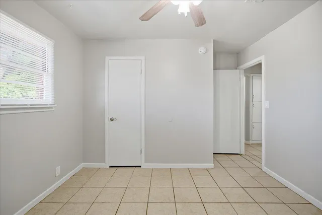an empty room with chandelier fan