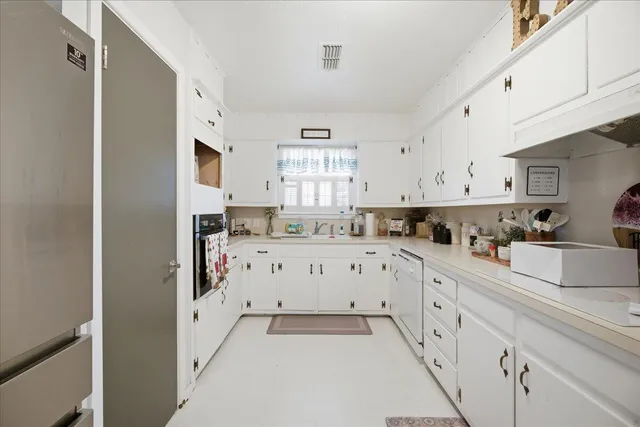 a kitchen with granite countertop white cabinets and white appliances