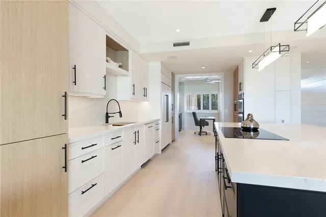 a large white kitchen with cabinets