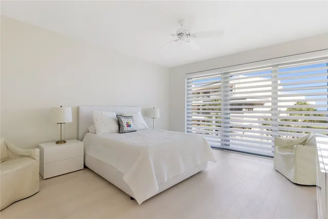 a bedroom with bed and a large window