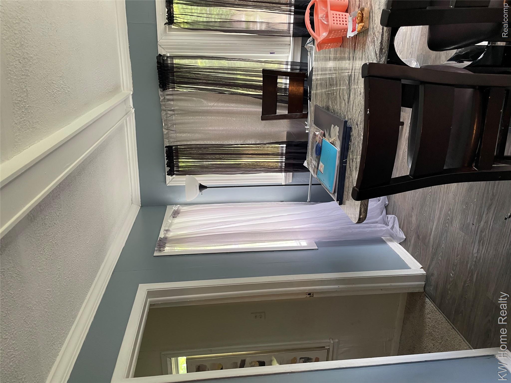 19350 Glastonbury Road Detroit, MI 48219 - Photo 6 of 11 Dining area featuring wood-finish flooring, a light blue wall color, white trim work, and multiple windows