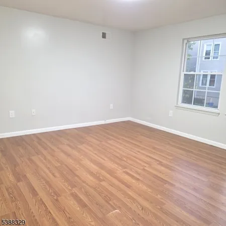 an empty room with wooden floor and a window