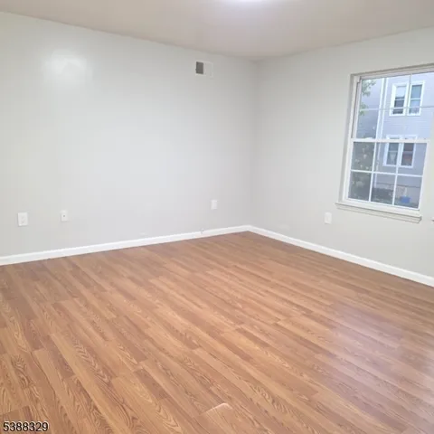 an empty room with wooden floor and a window