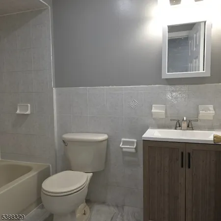 a bathroom with a sink vanity mirror and toilet
