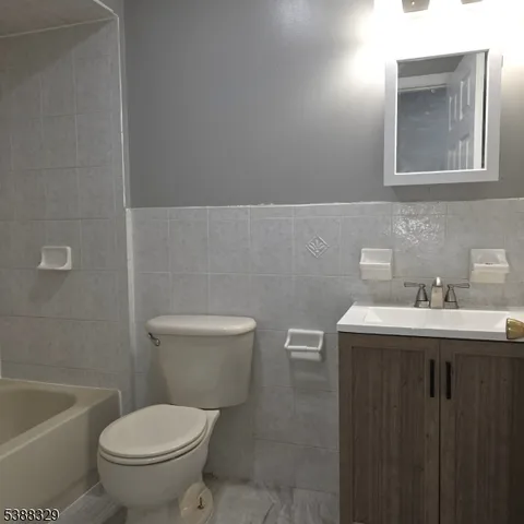 a bathroom with a sink vanity mirror and toilet