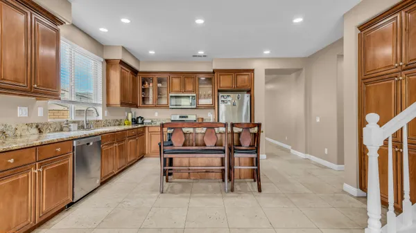 a kitchen with stainless steel appliances granite countertop a refrigerator a stove top oven a sink and dishwasher